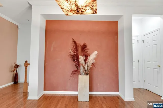 a view of a hallway with wooden floor and a potted plant