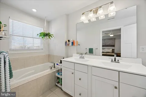 a bathroom with a tub a sink and mirror