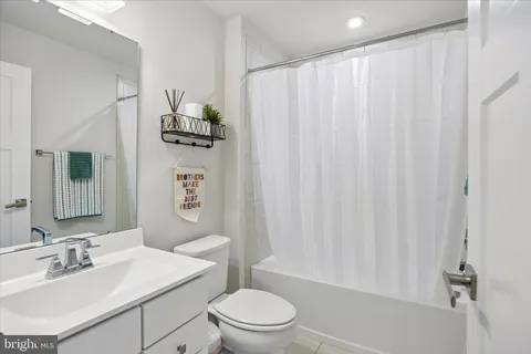 a bathroom with a sink a toilet and shower curtain