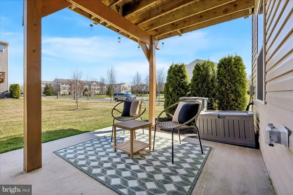 a view of a chair and tables in the patio with a backyard