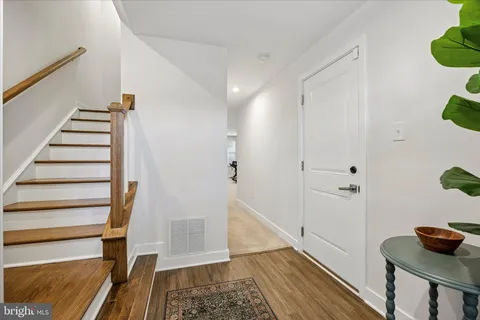 a view of a hallway with wooden floor and staircase