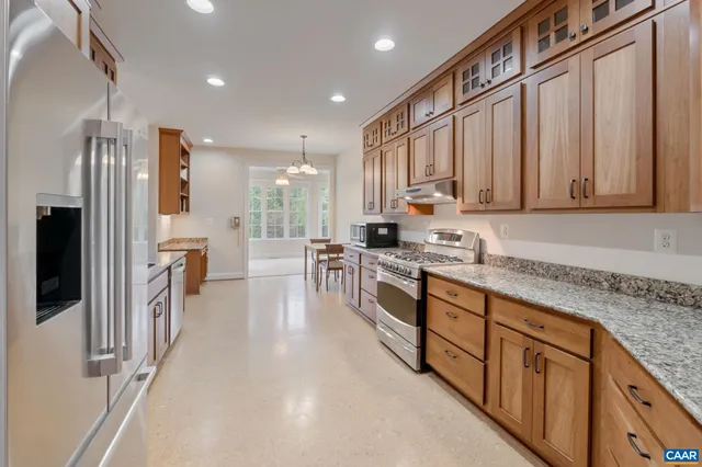 a kitchen with stainless steel appliances granite countertop a stove a sink and a refrigerator