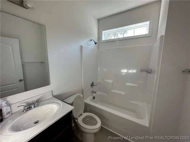 a bathroom with a sink mirror toilet and bathtub
