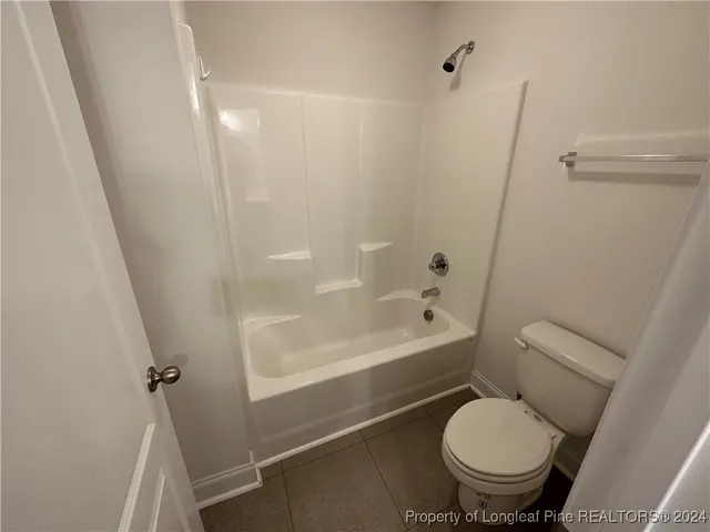 a bathroom with a granite countertop toilet a sink and a bathtub