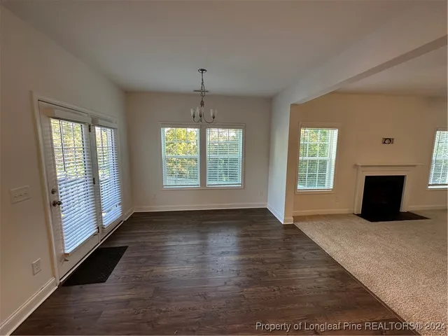 an empty room with wooden floor cabinet and windows