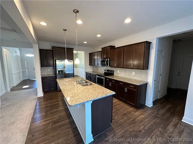 a large kitchen with stainless steel appliances kitchen island granite countertop a large counter top and stove