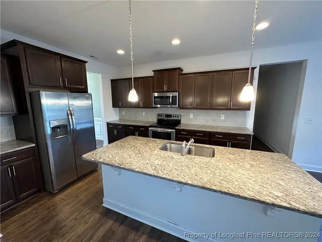 a kitchen with stainless steel appliances granite countertop a sink refrigerator and microwave