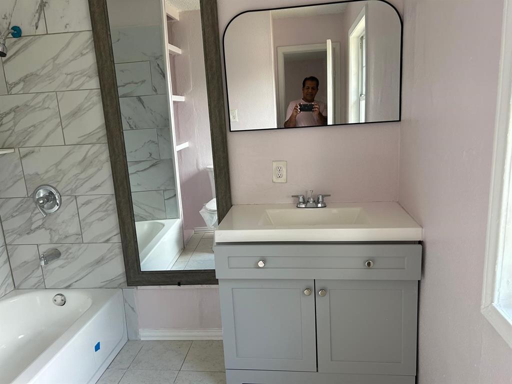 10034 Mill Valley Lane Dallas, TX 75217 - Photo 12 of 18 a bathroom with a tub sink and mirror