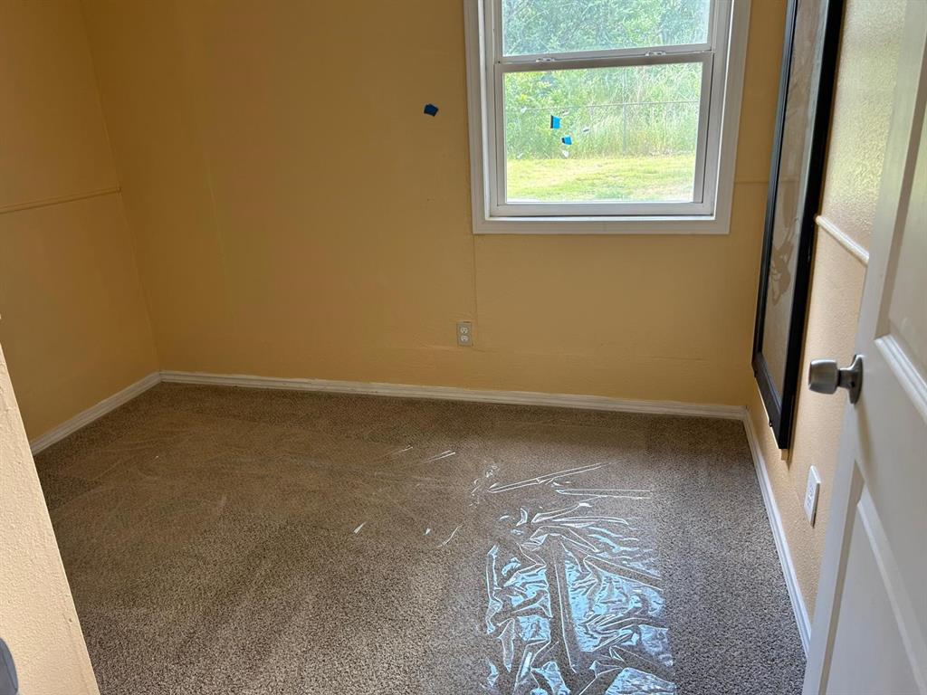 10034 Mill Valley Lane Dallas, TX 75217 - Photo 7 of 18 an empty room with a window