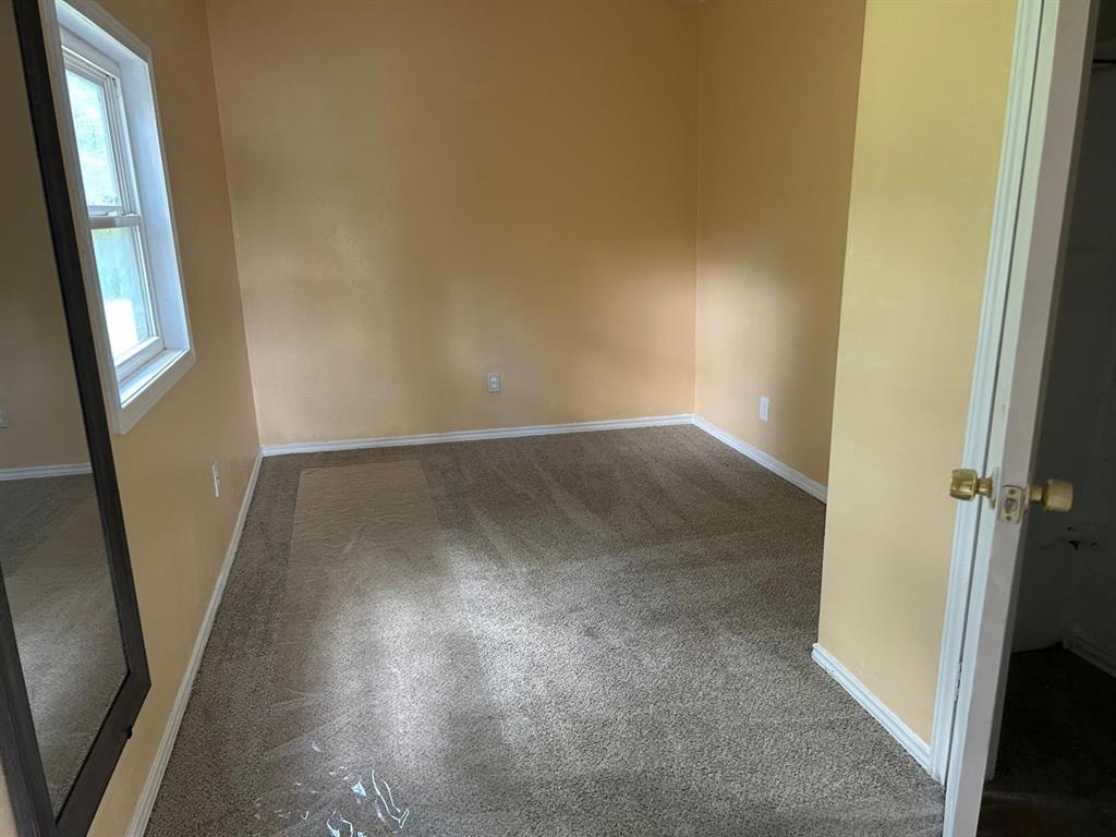 10034 Mill Valley Lane Dallas, TX 75217 - Photo 9 of 18 an empty room with wooden floor and entrance