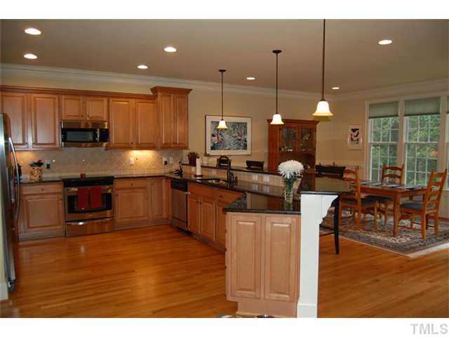 803 Running Brook Trail Raleigh, NC 27609 - Photo 7 of 21 Another angle of kitchen showing long eat-at bar and openess to dining area!