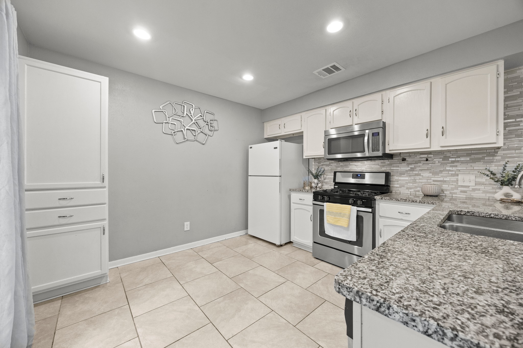 8330 Fathom Circle, Unit 501 Austin, TX 78750 - Photo 7 of 26 a kitchen with granite countertop a refrigerator and a stove top oven