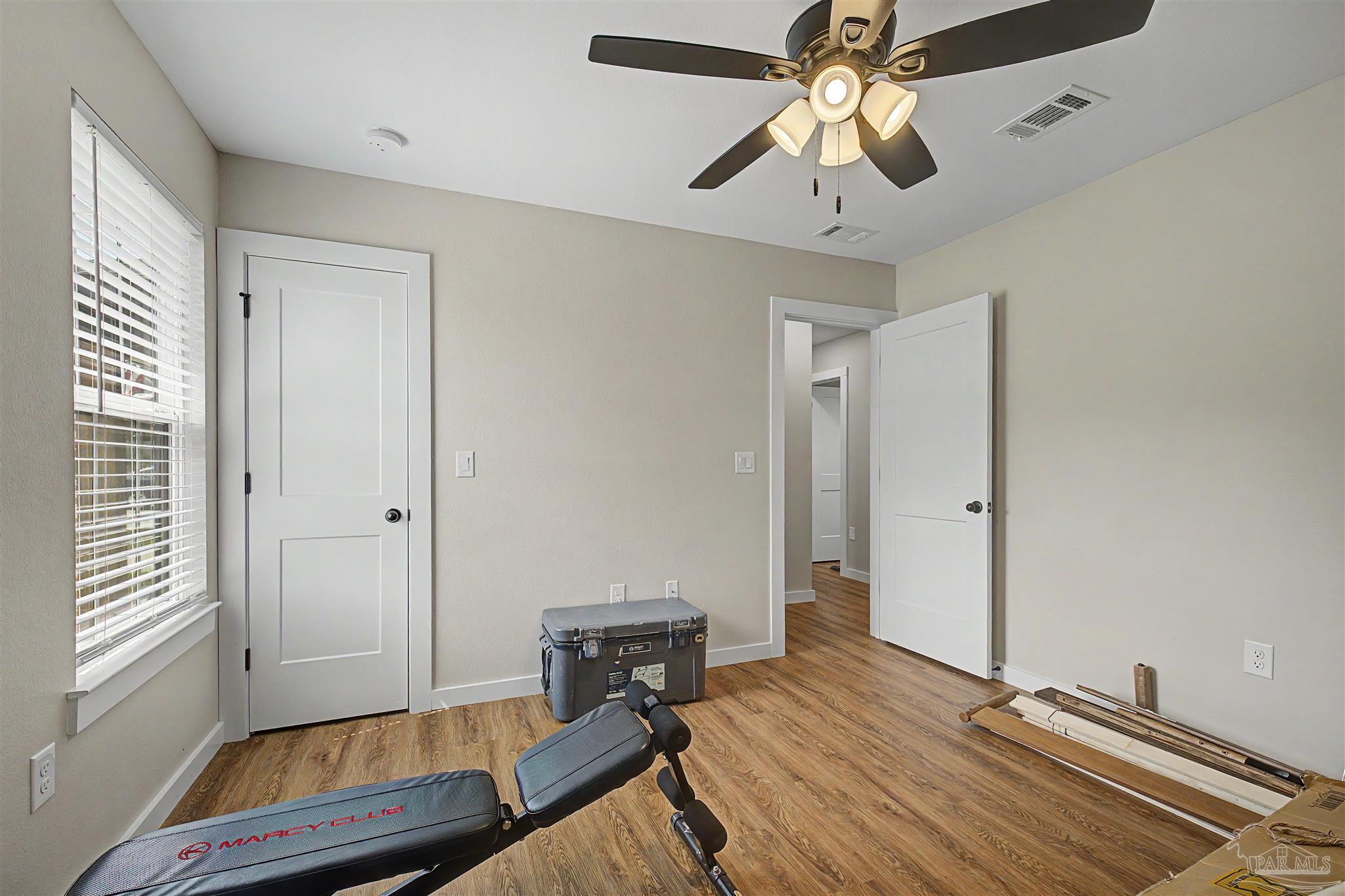 2549 Ten Mile Road Pace, FL 32571 - Photo 27 of 46 a bedroom with a bed and a chandelier fan