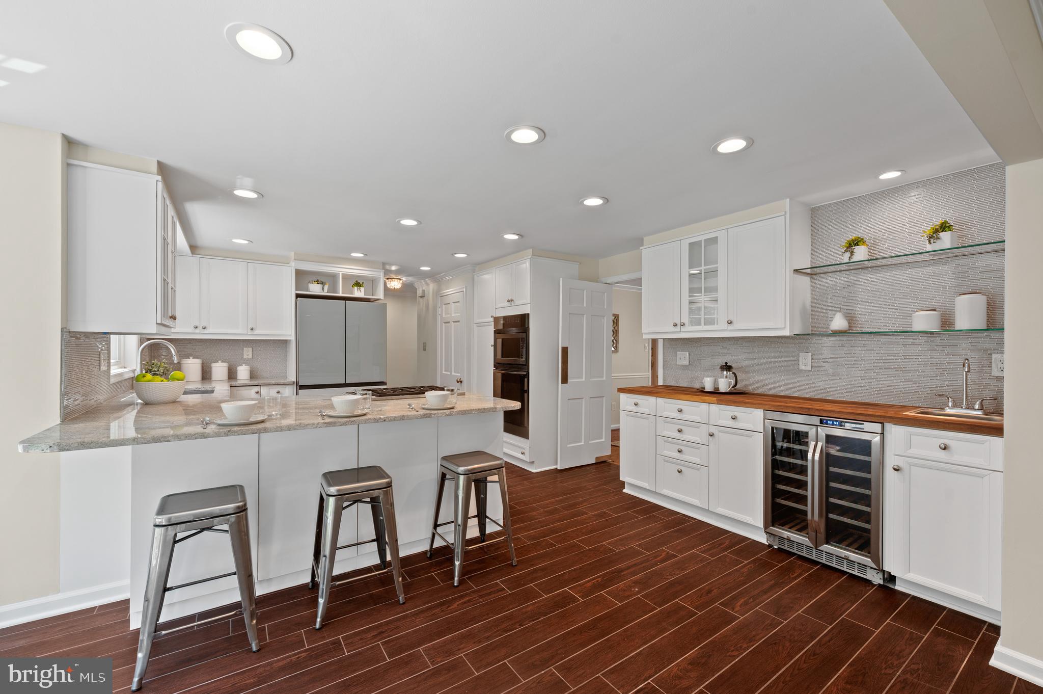 813 Malin Road Newtown Square, PA 19073 - Photo 26 of 55 a large kitchen with kitchen island a island a stove a cabinets and a dining table with wooden floor