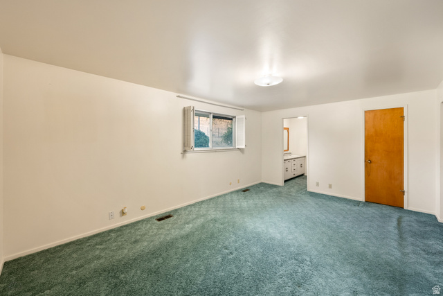 1940 West Old Hwy Road Morgan, UT 84050 - Photo 40 of 73 Spacious room featuring light-colored walls, green carpeting, a window with exterior shutters, and a flush-mount ceiling light fixture