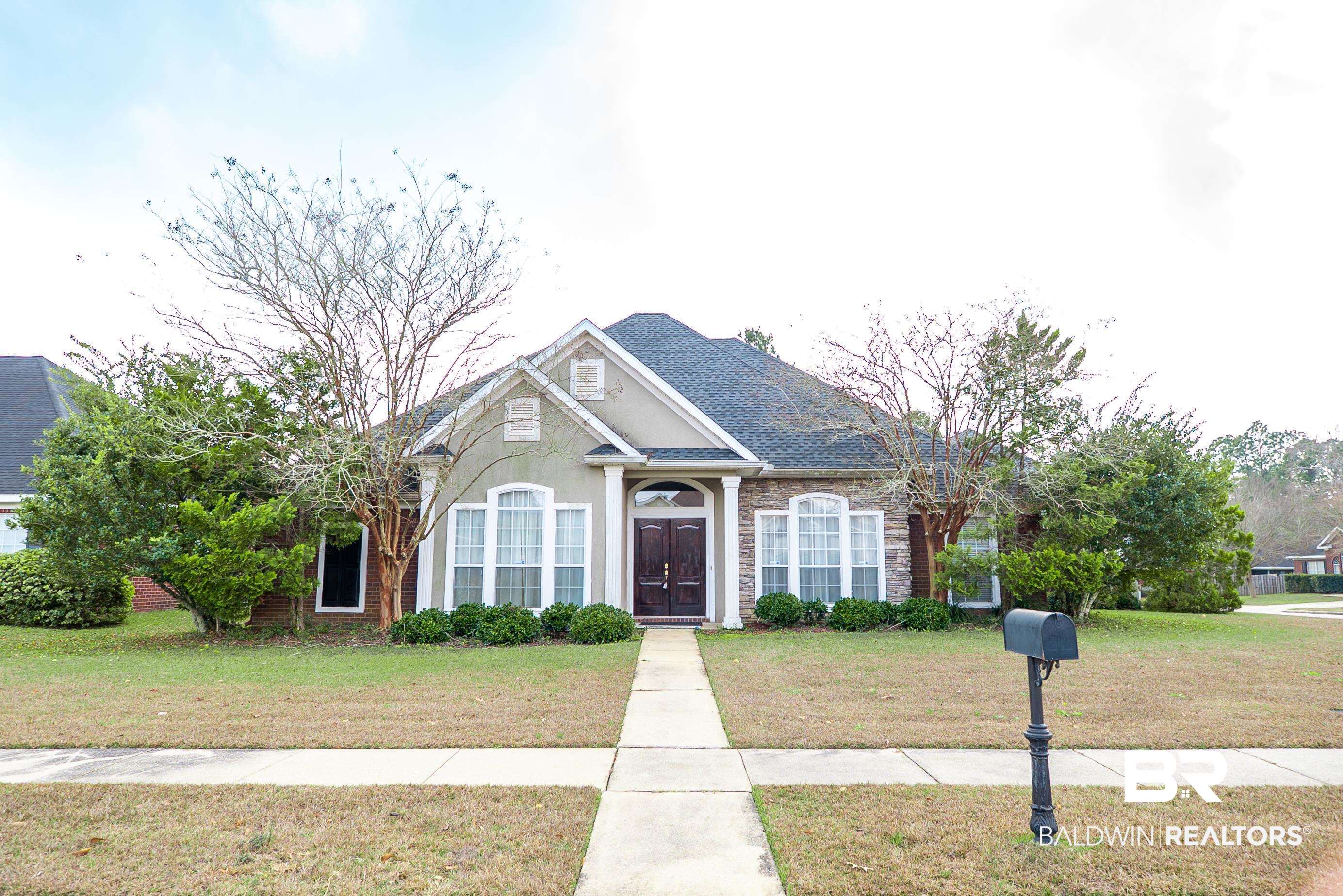 10023 Springfield Court Mobile, AL 36695 - Photo 1 of 50 View of front facade featuring a front lawn, a shingled roof, and stucco siding