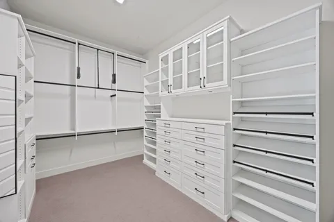 a view of walk in closet with empty racks