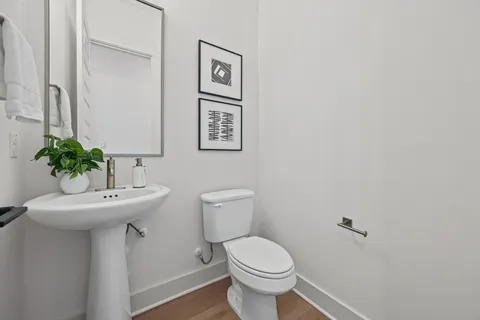 a bathroom with a toilet sink and mirror