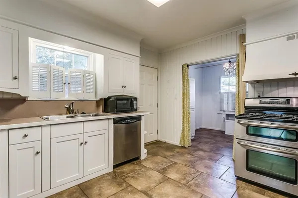 a kitchen with granite countertop a sink stainless steel appliances and cabinets