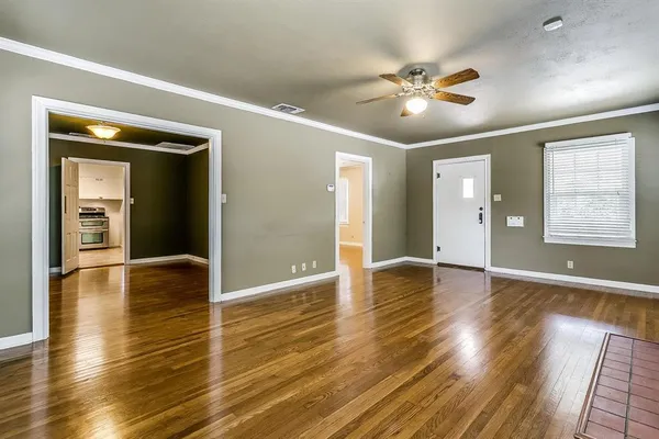 a view of an empty room with wooden floor