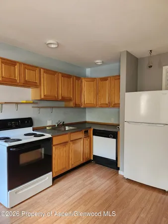 a kitchen with granite countertop wooden cabinets stainless steel appliances and a window