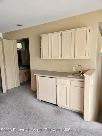 a kitchen with granite countertop white cabinets and refrigerator