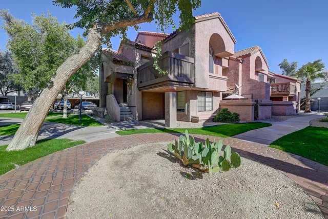 a front view of a house with a yard and potted plants