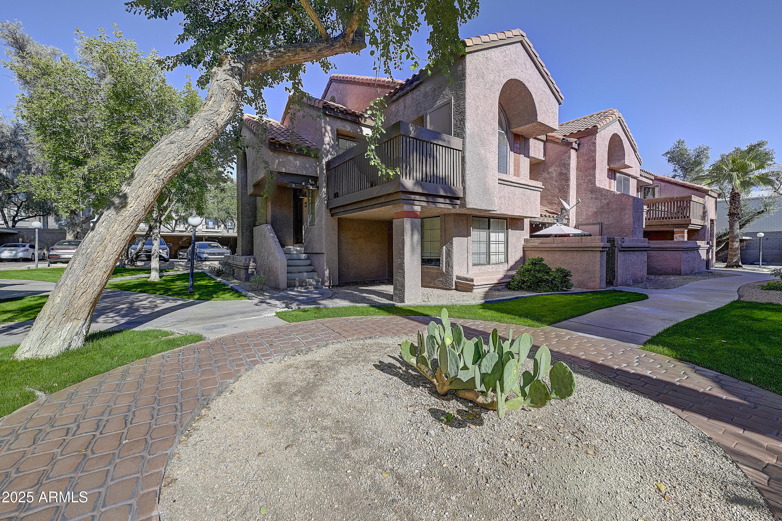 a front view of a house with a yard and potted plants