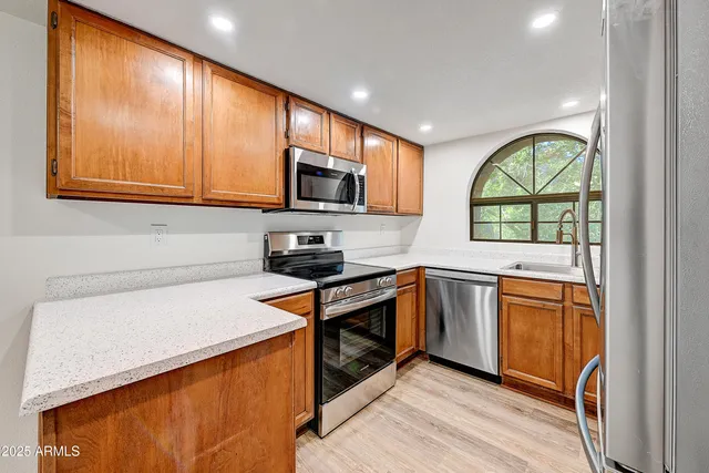 a kitchen with stainless steel appliances granite countertop a stove a sink and a microwave
