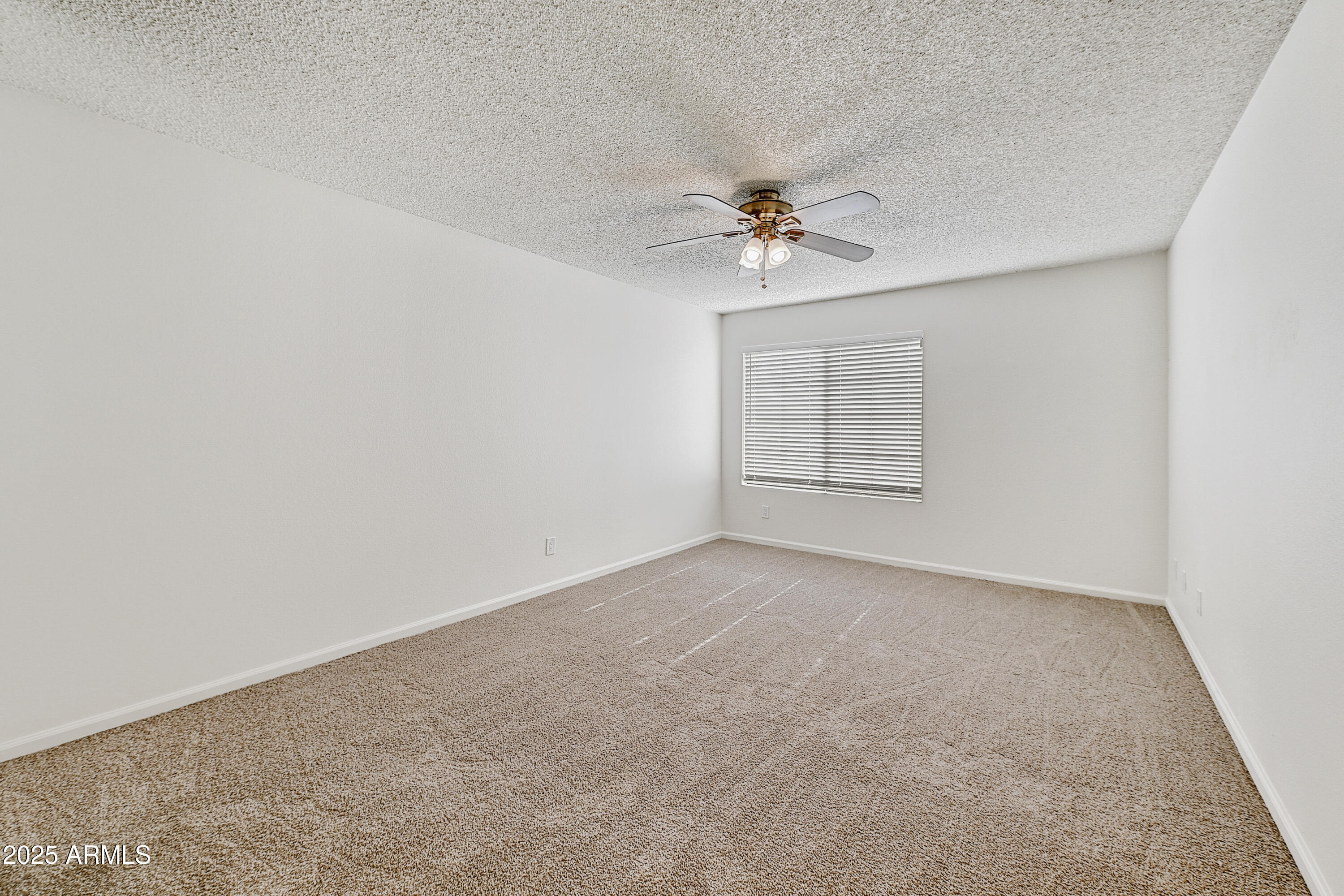 925 North College Avenue, Unit E217 Tempe, AZ 85288 - Photo 18 of 32 an empty room with chandelier fan and windows