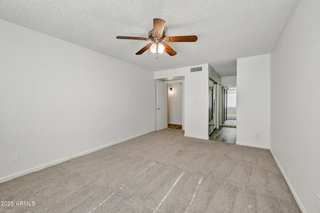 a view of empty room with ceiling fan