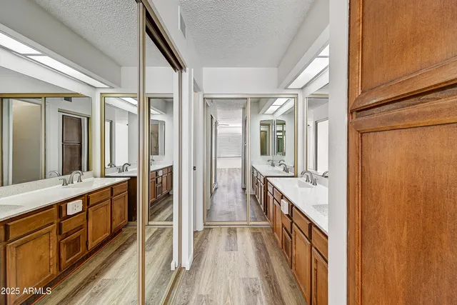 a bathroom with a double vanity sink and mirror with shower