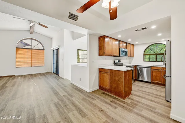 a kitchen with stainless steel appliances granite countertop a stove a sink and a wooden floors