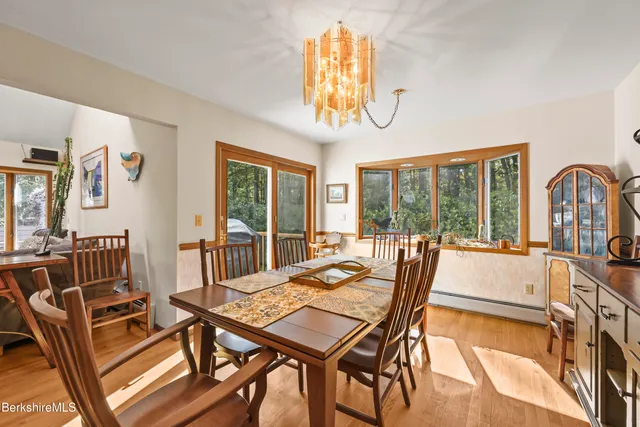 a view of a dining room with furniture a chandelier and wooden floor