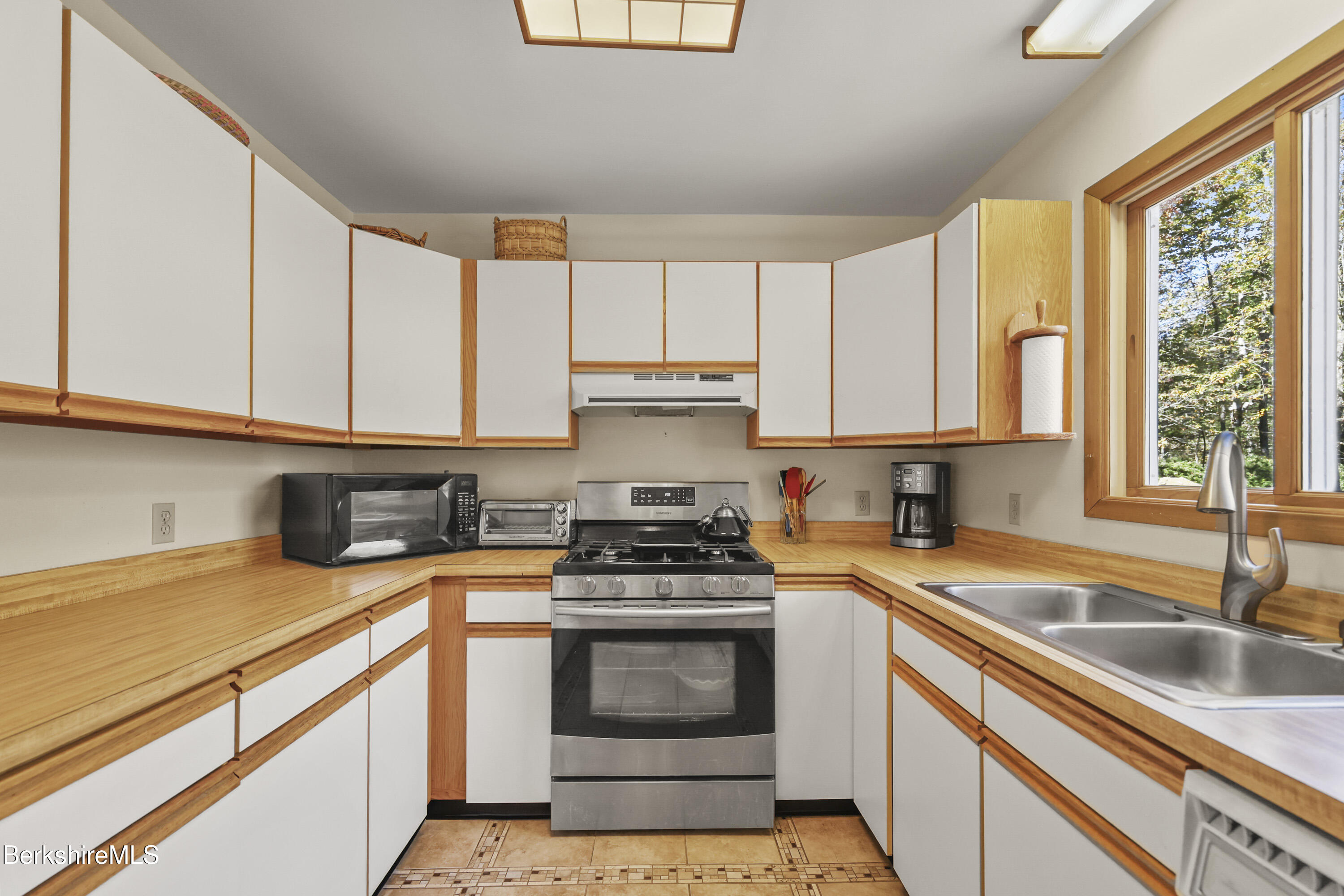 337 Captain Whitney Road Becket, MA 01223 - Photo 17 of 53 a kitchen with granite countertop a sink stainless steel appliances and cabinets