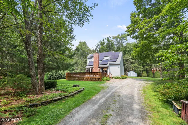 a view of a big house with a big yard plants and large trees