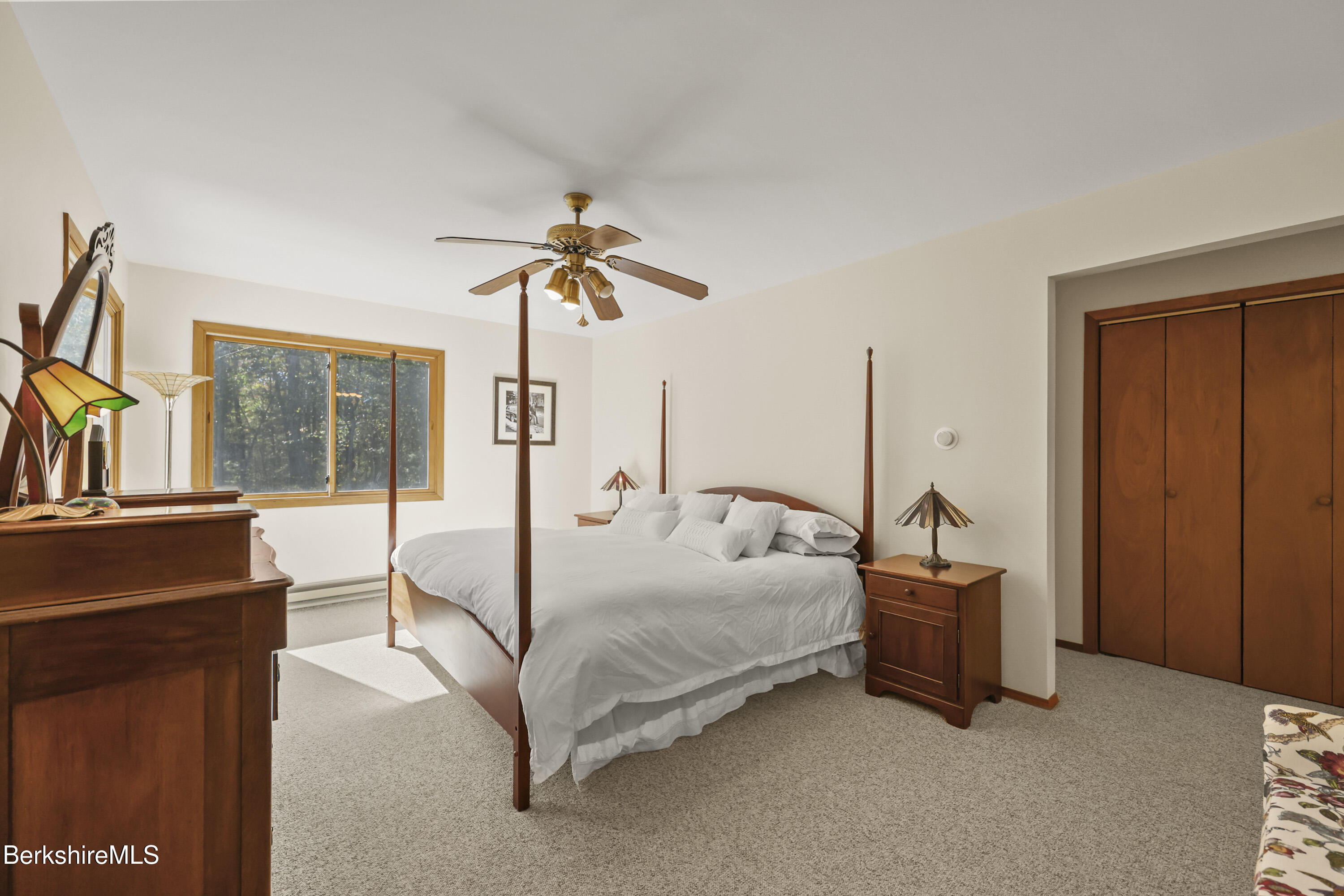 337 Captain Whitney Road Becket, MA 01223 - Photo 30 of 53 a bedroom with a bed and a chandelier