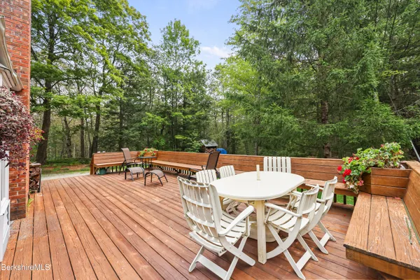 a view of a patio with table and chairs and couches with wooden floor and fence