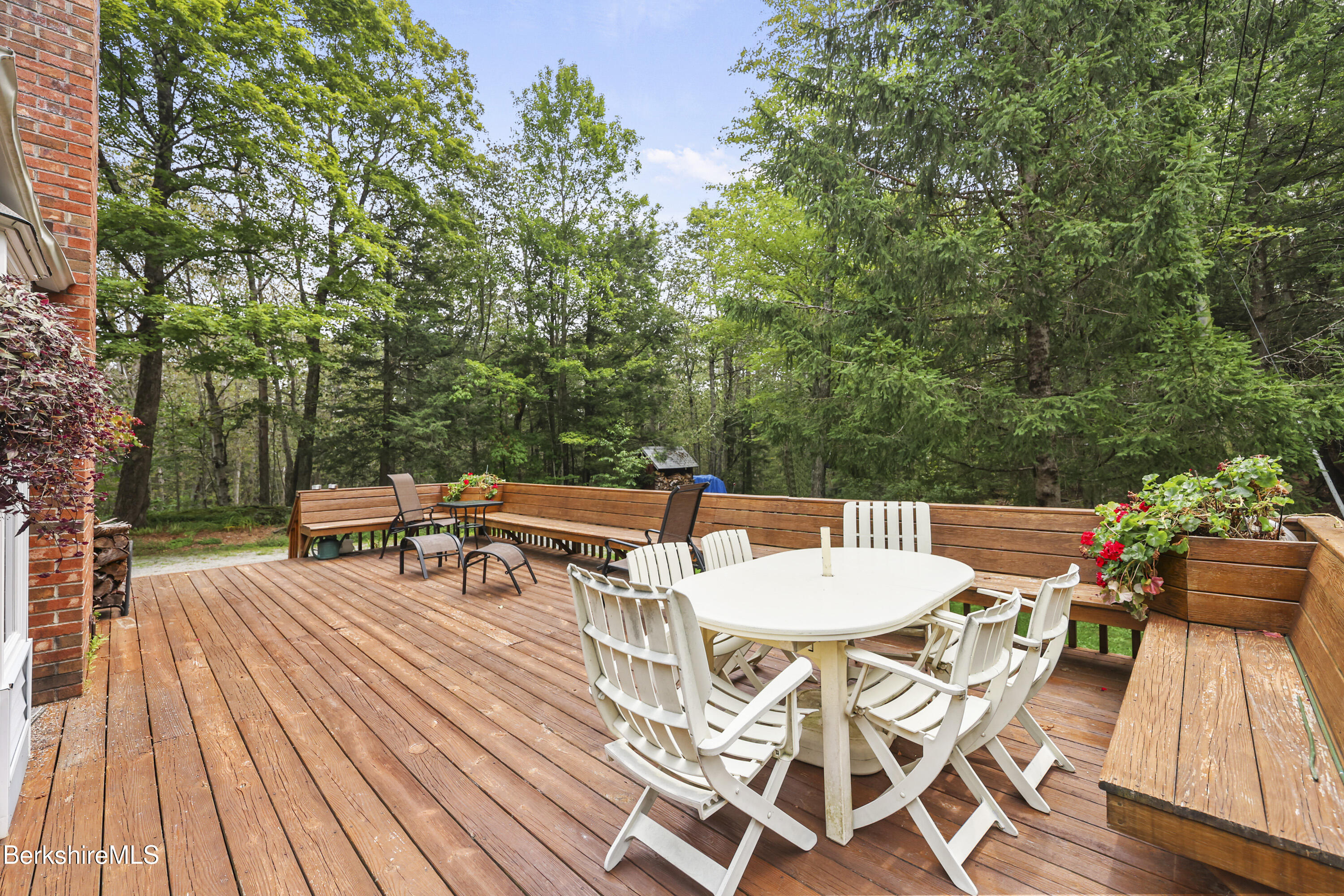 337 Captain Whitney Road Becket, MA 01223 - Photo 6 of 53 a view of a patio with table and chairs and couches with wooden floor and fence
