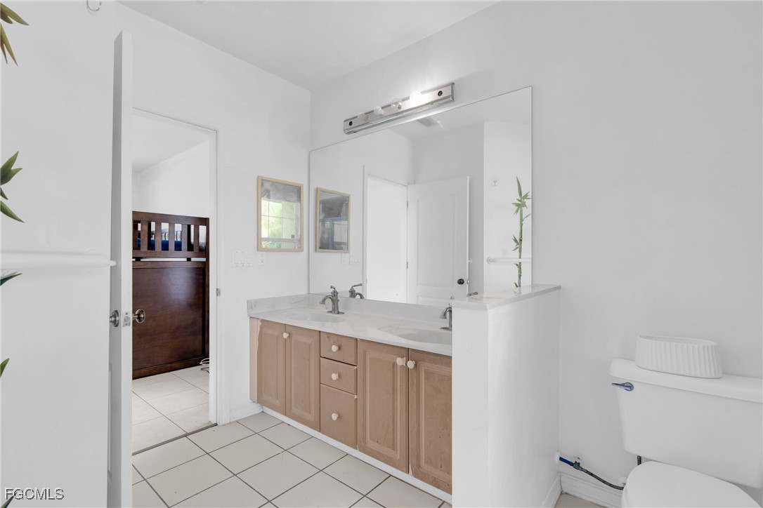 809 Hamilton Avenue Lehigh Acres, FL 33972 - Photo 11 of 25 a bathroom with a granite countertop sink mirror and toilet