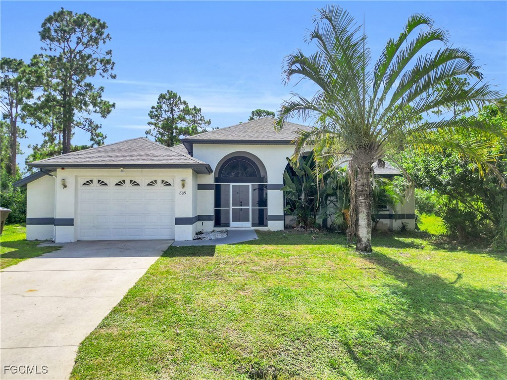 809 Hamilton Avenue Lehigh Acres, FL 33972 - Photo 4 of 25 a view of a house with pool and a yard