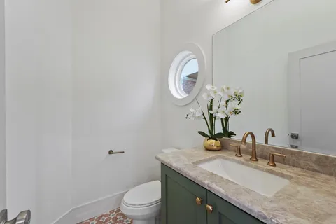 a bathroom with a granite countertop sink a toilet and a mirror