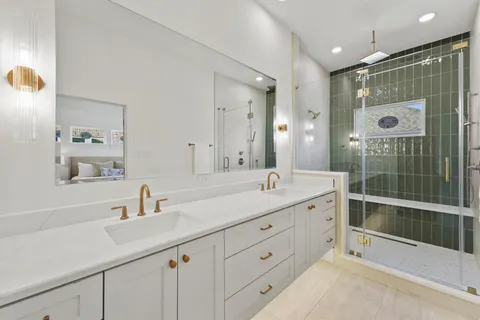 a bathroom with a shower sink double vanity and mirror