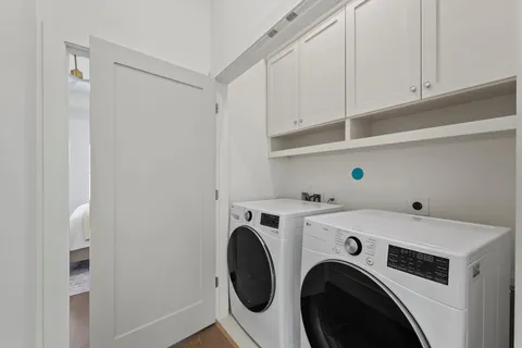 a view of washer and dryer with kitchen in the background