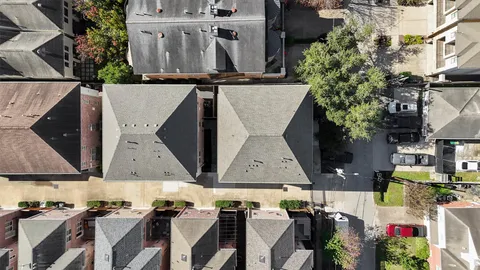 an aerial view of a house with wooden floor and large trees