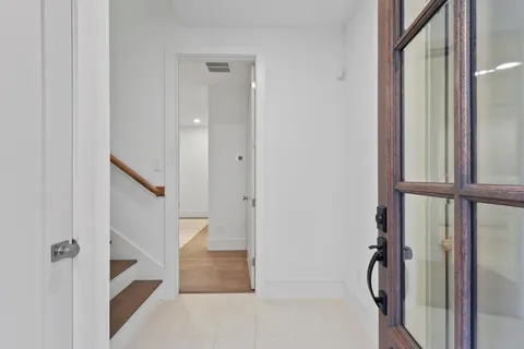 a view of staircase with white walls and door