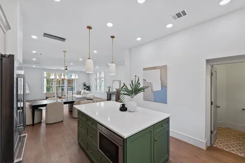 a kitchen with kitchen island a sink appliances and wooden floor