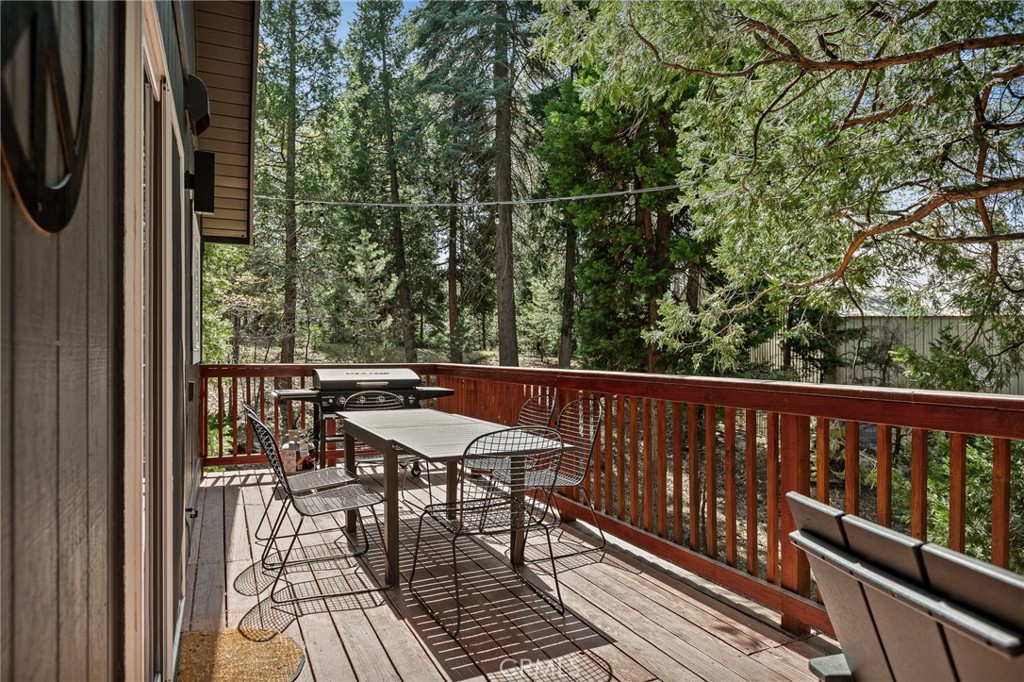 373 Summit Road Lake Arrowhead, CA 92352 - Photo 17 of 41 a balcony with wooden floor table and chairs