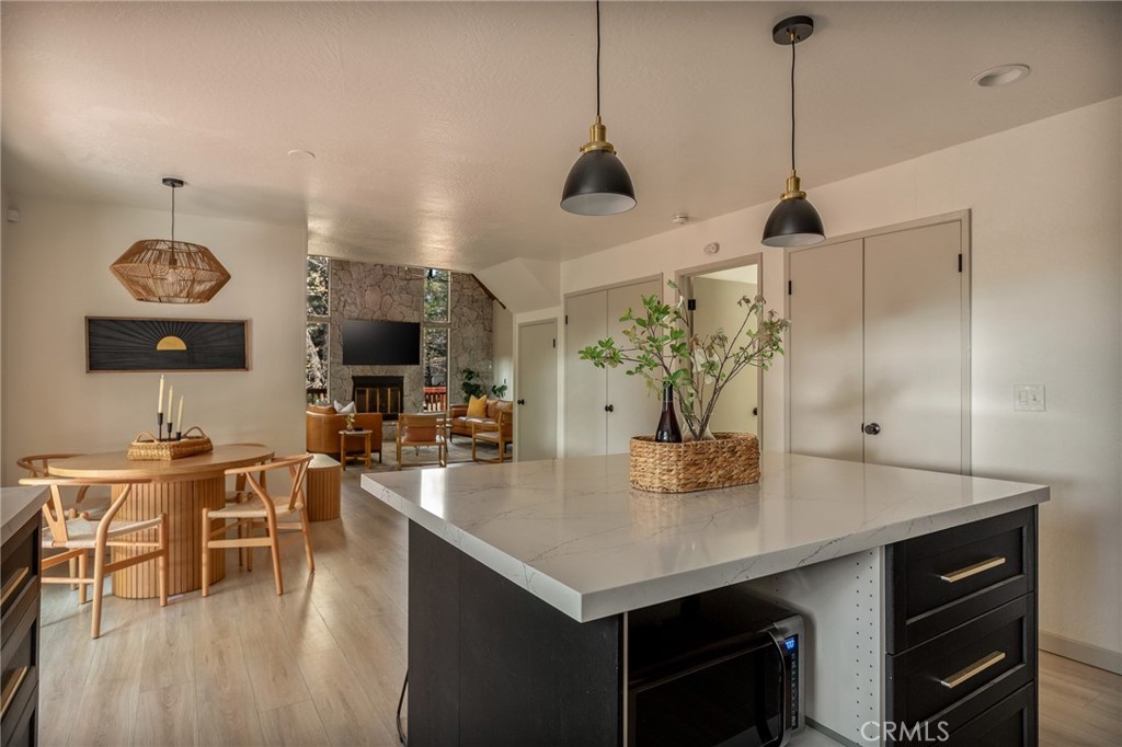 373 Summit Road Lake Arrowhead, CA 92352 - Photo 5 of 41 a view of a dining room and livingroom with furniture wooden floor a rug a fireplace and a chandelier