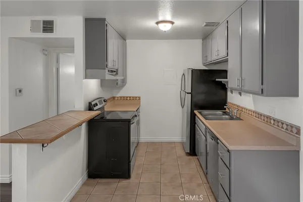 a kitchen with stainless steel appliances granite countertop a sink refrigerator and cabinets